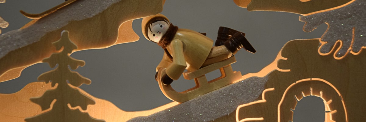 Schwibbogen Winterlandschaft – Figur auf Schlitten in Nahaufnahme
